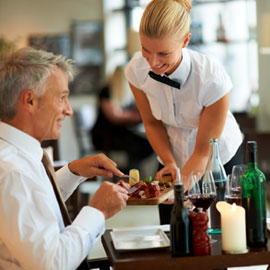A waitress helps customers at a restaurant